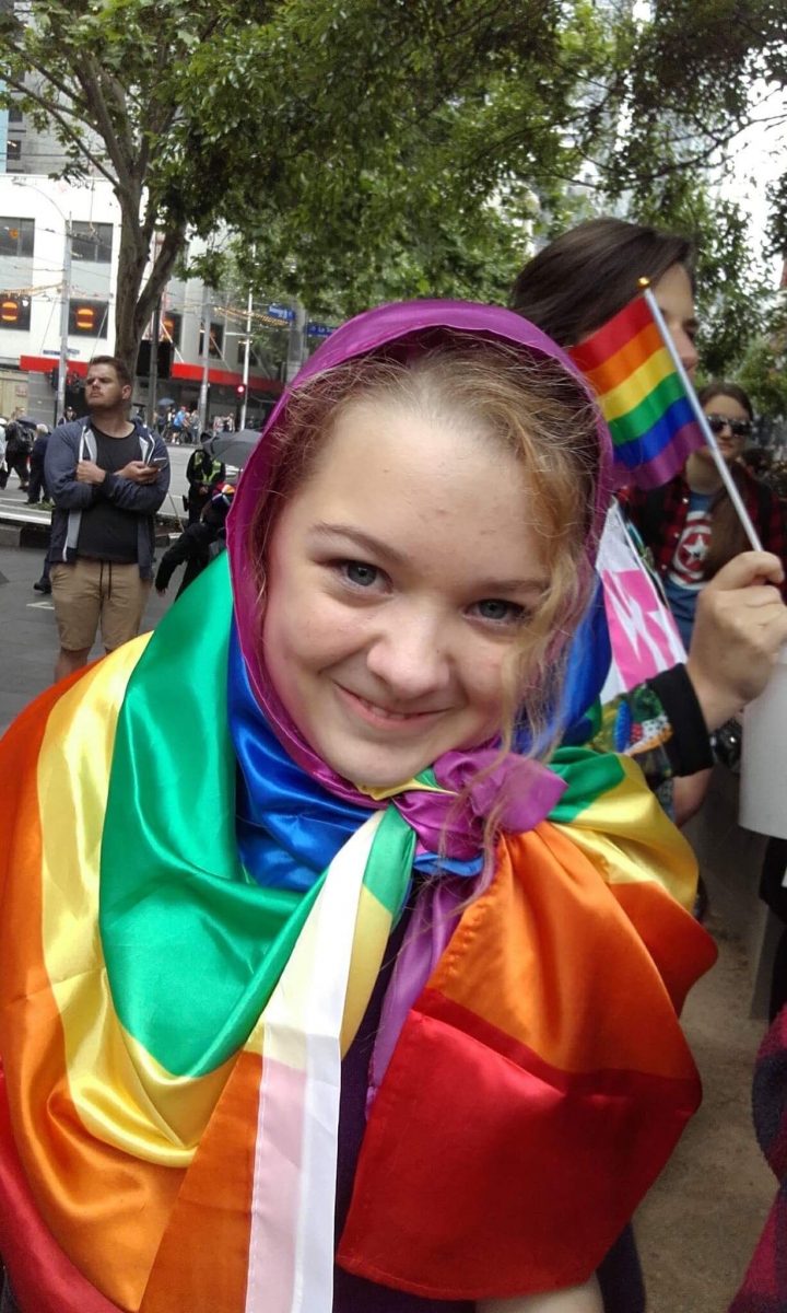 girl wrapped into a rainbow flag girl wrapped into a rainbow flag