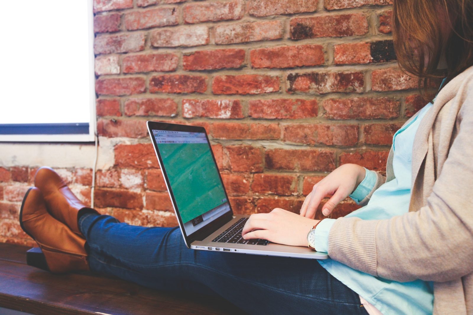 woman sitting on a bench using a laptop woman sitting on a bench using a laptop