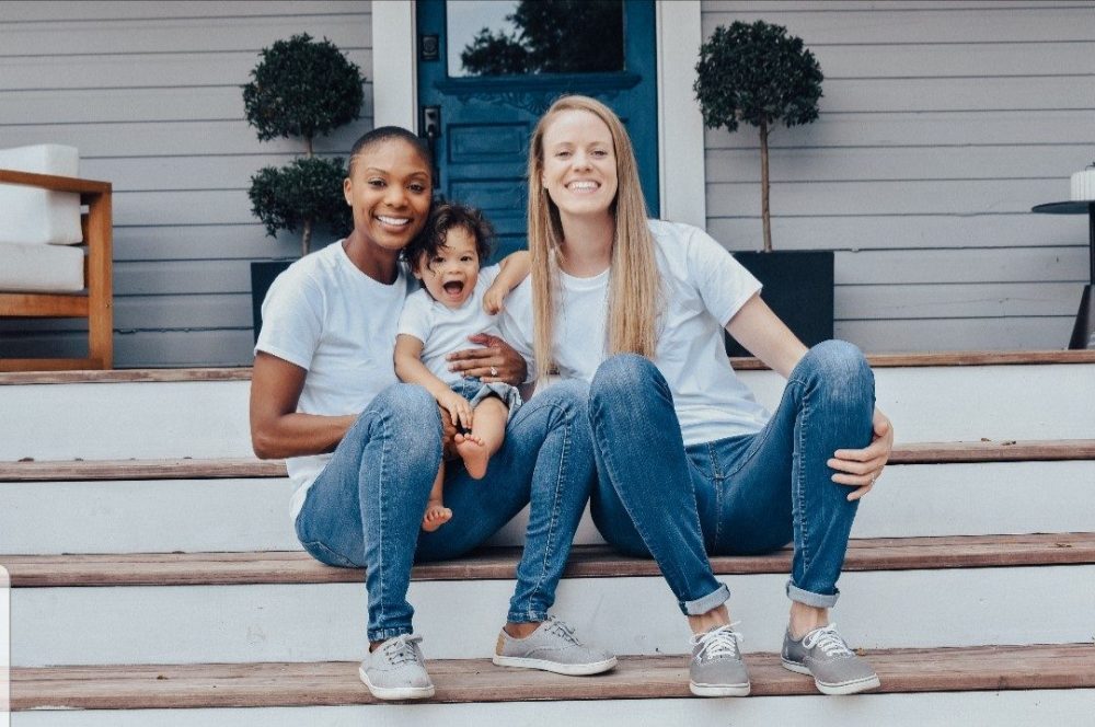 Lesbian Parents with toddler sitting on verandah 